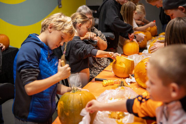 Børn skærer uhyggelige Halloween-græskar